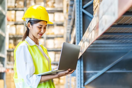 Portrait of asian woman warehouse worker in uniform checks stock and inventory with digital laptop computer, working in delivery, distribution center, logistic and business export photo