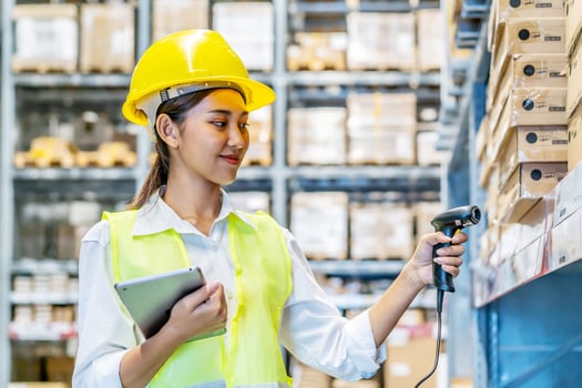 Female employee worker scanning products on shelves in warehouse, working with scanner for merchandise distribution. Young adult reviewing stock logistics before order shipment in depot. photo