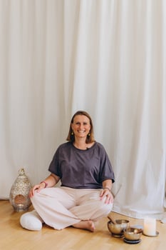 A woman sits on the floor with her eyes closed, practicing deep breathing exercises. She inhales and exhales slowly photo