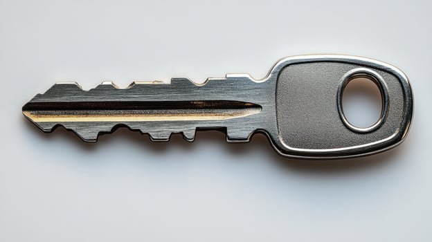 Close-up of a shiny metal key on a light background, showcasing reflections photo