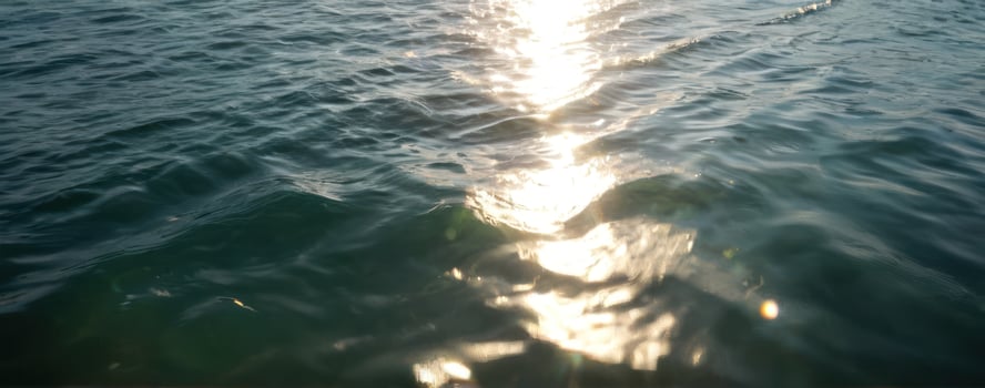 The sun shines through the water on a boat photo