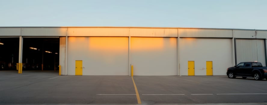 A car is parked in front of an industrial building photo