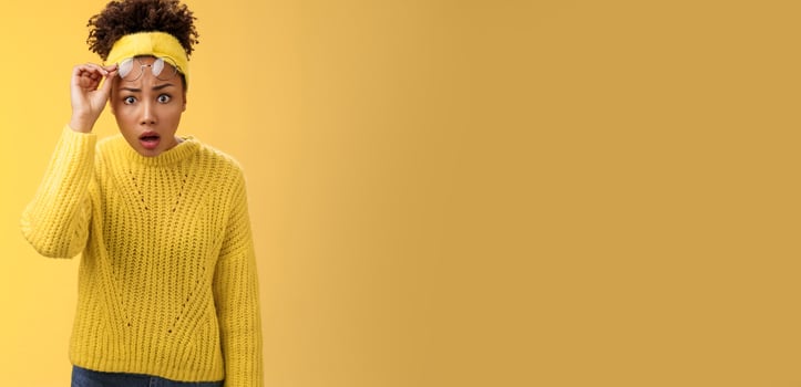 Concerned amazed speechless african-american student girl drop jaw take-off glasses widen eyes surprised been dropped-out look unbelievable thing, standing questioned frustrated, yellow background photo
