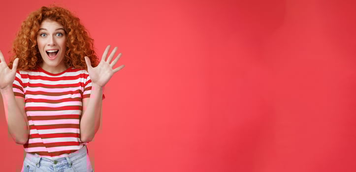 Extremely wonderful news she excited. Thrilled emotive gorgeous redhead woman scream amazed awesome surprise raise hands waving impressed open mouth stare charmed fascinated red background photo