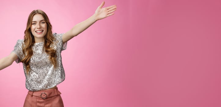 Come into my arms. Portrait friendly outgoing charming cute caucasian female wearing glittering blouse extend arms sideways wanna embrace cuddle friend welcoming hugging guests, smiling broadly photo
