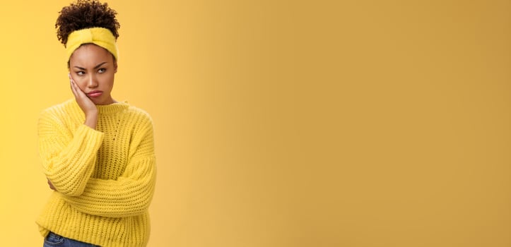 Offended gloomy grumpy pouting young african-american girlfriend feel irritated jealous frowning bothered sulking look away insulted unwilling talk somebody lean hand head standing yellow background photo