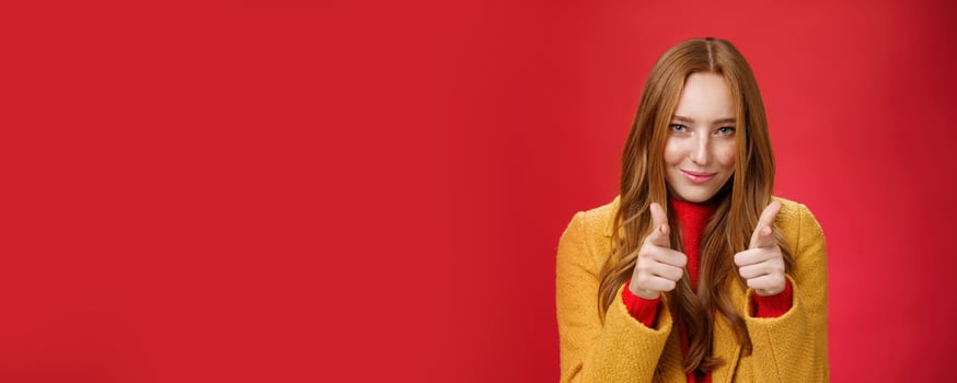 Nice job it was awesome. Portrait of sassy and cheeky good-looking redhead female with freckles and blue eyes smiling sensually with satisfied grin showing thumbs up in approval and like gesture photo