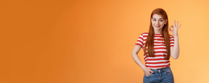 Very good. Pleased cute female showing okay sign and smiling satisfied, grinning delighted recieve positive result, hold hand pocket assertive, self-assured pose, agree, accept terms, recommend photo