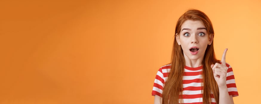 Got idea. Excited redhead woman sharing interesting plan, raise index finger eureka gesture, open mouth say thought, remember important thing, stare camera stunned, finally understand photo