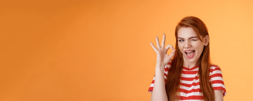 I got under control. Sly creative redhead cheerful girl assuring you everything fine, hinting good promo, wink flirty opened mouth, show okay approval, accept gesture, judge sense style photo