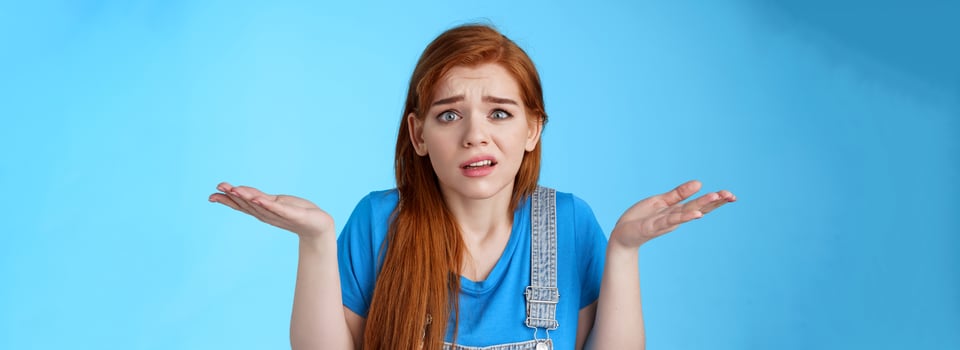 Perplexed uneasy stupified worried redhead woman shrugging, have no idea, frowning nervously, cannot understand what happened, stand clueless unsure, pose blue background photo