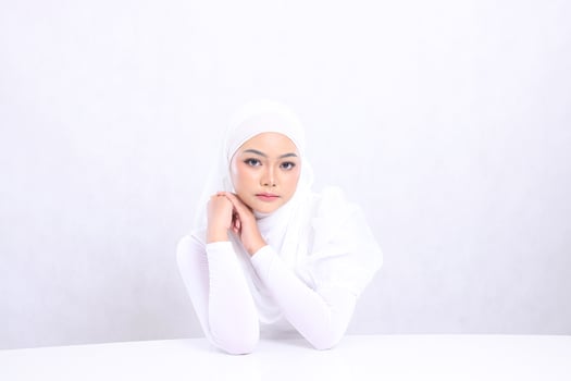 portrait charm Young woman hijab beautiful elegant look at camera hands on white table and parallel clenched isolated white background. concept cosmetics, health, skin care, Facial treatment photo
