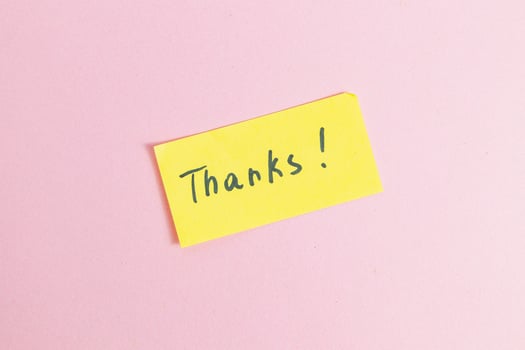 Yellow small note with the word thank you on a pink background in the center photo