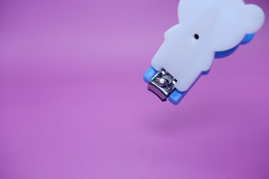 cute nail clippers isolated on purple background. cute nail clippers with blue and white color combination photo
