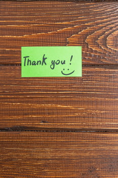 A small green note with the word thank you on a turf table photo