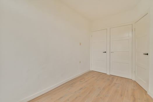 An empty room with white walls and wooden floors photo