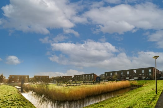 A canal with grass and trees in the foreground photo
