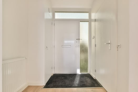 A hallway with a door and a black rug photo