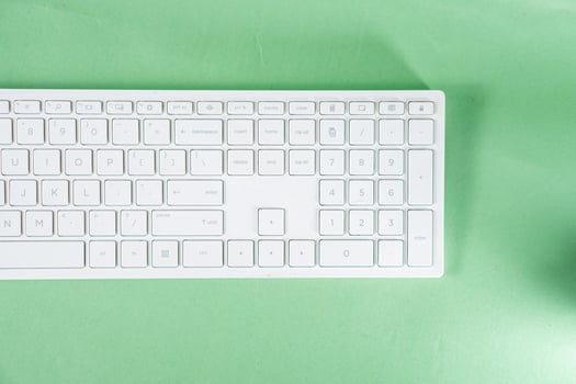 A white keyboard and mouse on a green background photo