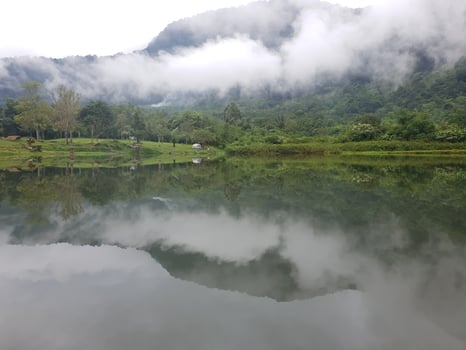 View of lake and and mountain with fog in it photo