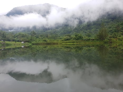 View of lake and and mountain with fog in it photo