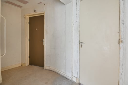 An empty room with a door and a wall photo
