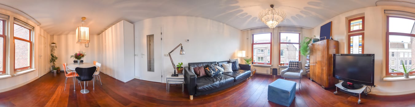 A 360 - view of a living room with a couch and a television photo