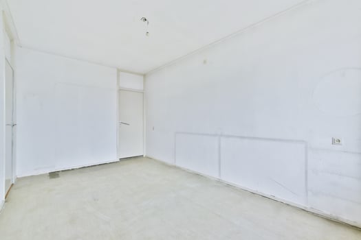 An empty room with white walls and a door photo