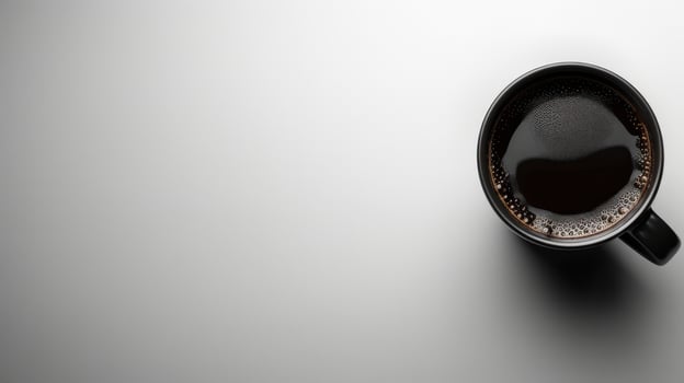 A single cup of coffee sits on a white surface photo