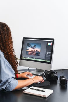 Female photographer editing a photo on a computer.