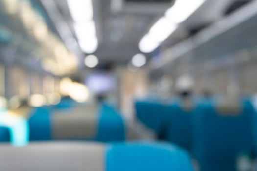 Blurry background of interior inside train. People are sitting for travelling photo