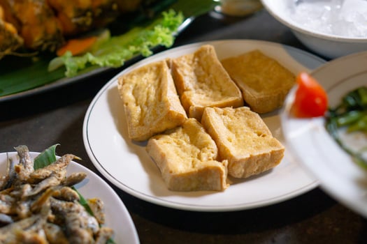 Tahu goreng or fried tofu prepared in white plate. Asian dish and Indonesia local food. photo