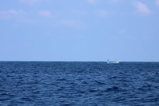 A small fishing boat in the middle of the sea photo