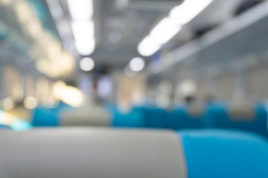Blurry background of interior inside train. People are sitting for travelling photo