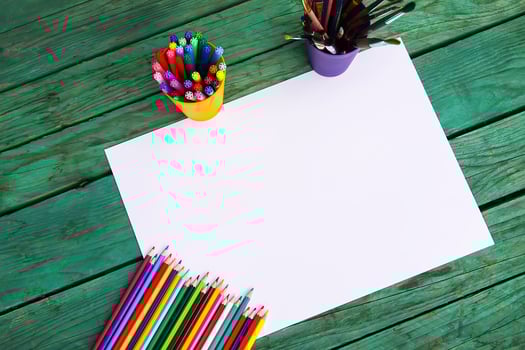 White paper sheet and school supplies on wooden aged background. photo