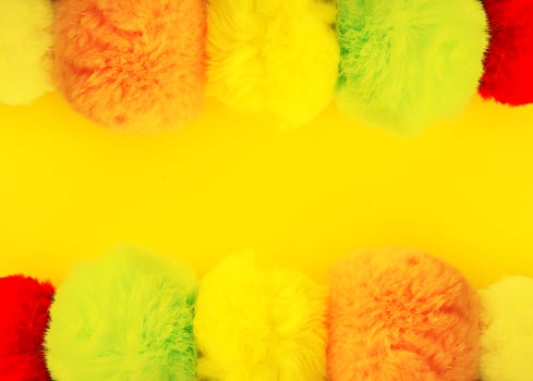 Colorful fluffy pompons on bright background. Fashion decoration festive template. photo