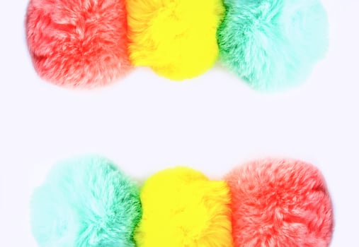 Colorful fluffy pompons on white background. Fashion decoration festive template. photo