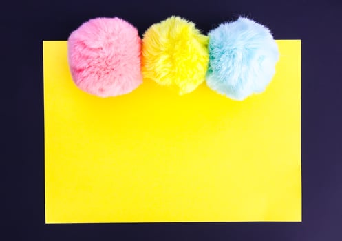 Colorful fluffy pompons on bright background. Fashion decoration festive template. photo