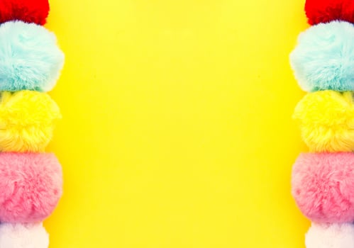 Colorful fluffy pompons on bright background. Fashion decoration festive template. photo