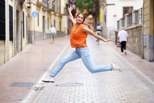 Woman jumping and opening arms in the city photo