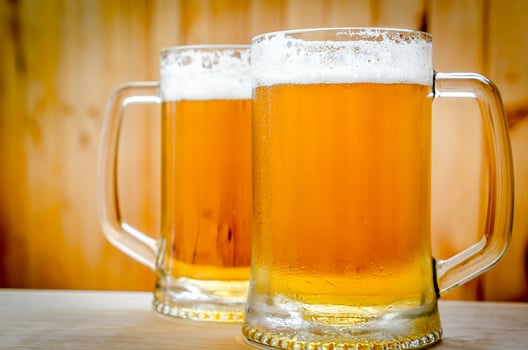 Two beer mugs on the wooden background photo