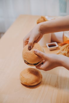 Binge eating disorder concept with woman eating fast food burger, fired chicken , donuts and desserts photo