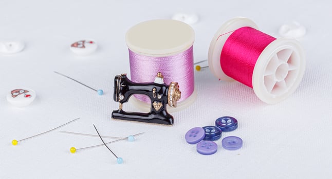 still life of a skein of thread for sewing, needles, buttons, sewing machine on a white background photo