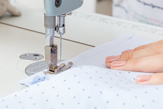 Female hands of a master tailor at work, a sewing machine needle photo