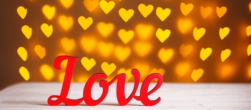 the inscription Love on a wooden background with beautiful hearts made of lights on a blurred background photo