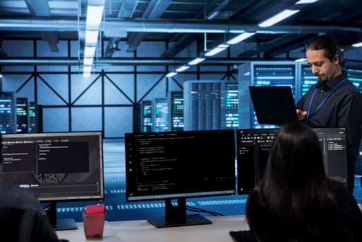 Admin doing yearly checkup to prolong data center electronics life span and avoid downtime. Employee in server room monitoring server infrastructure components using laptop photo