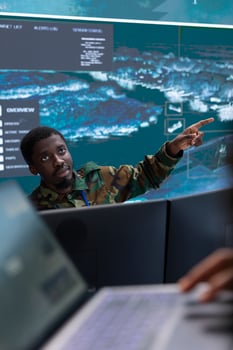Army specialists use advanced computer systems and big screen to gather intelligence, studying radar satellite data to enhance national security. High tech military control room base of operations. photo