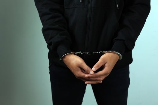 Man with Black Jacket in Handcuffs photo