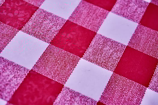 Red and white square checkered fabric table top pattern material isolated on horizontal ratio full frame background. photo