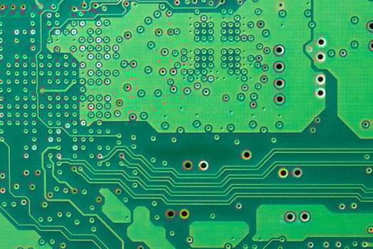 Close-up of a green printed circuit board with electronic components and chips photo